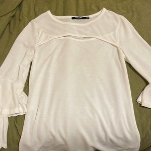 White blouse. Ruffled sleeves. Cut out at the top.